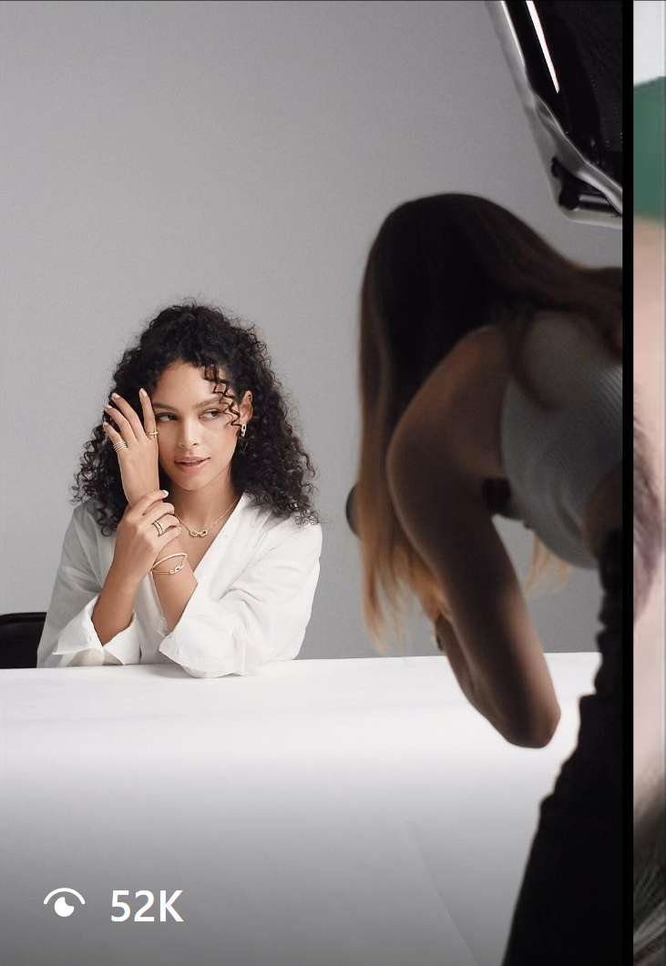 Behind-the-scenes shot of a model showcasing Mavie jewelry, with a photographer capturing elegant gold rings and bracelets.