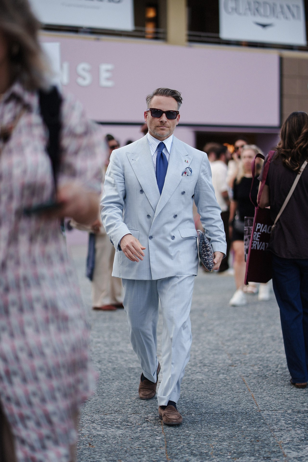 Pitti Uomo 110 guest arriving in pale blue suit and blue tie outside Fortezza da Basso
