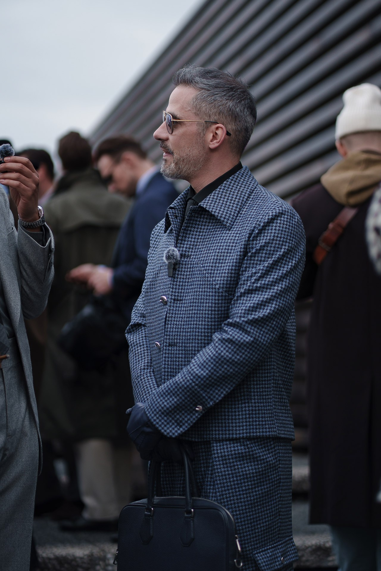 Man in patterned suit holding phone at Pitti Uomo 109 Florence
