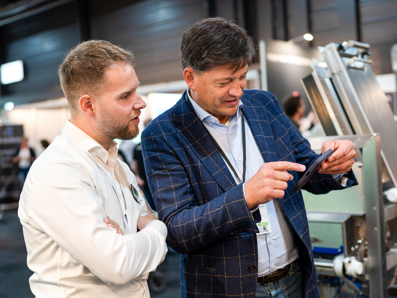 Trade fair visitors discussing a product using a tablet