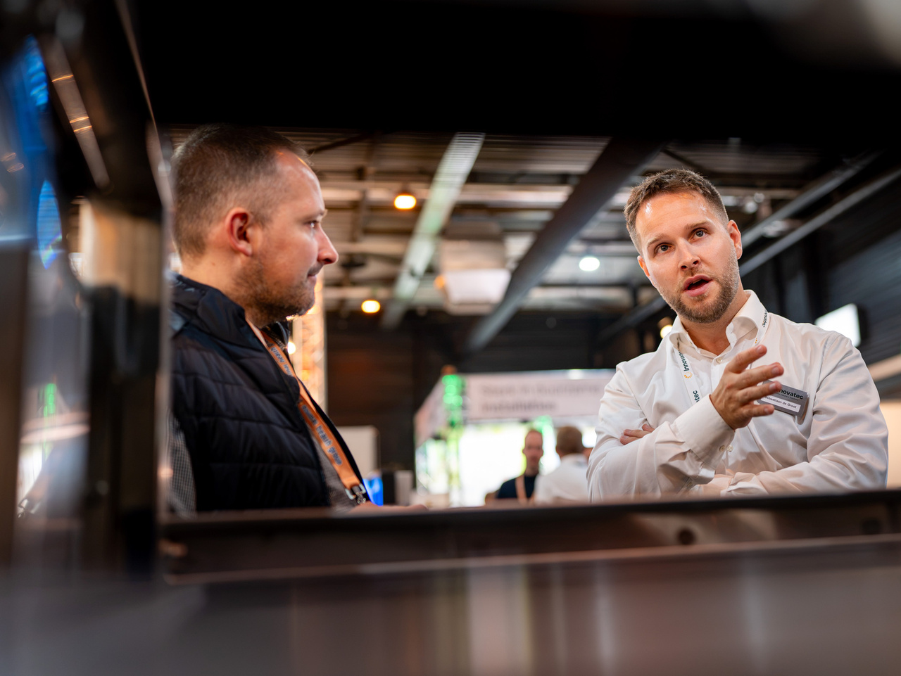 Visitors and exhibitors interacting around industrial equipment