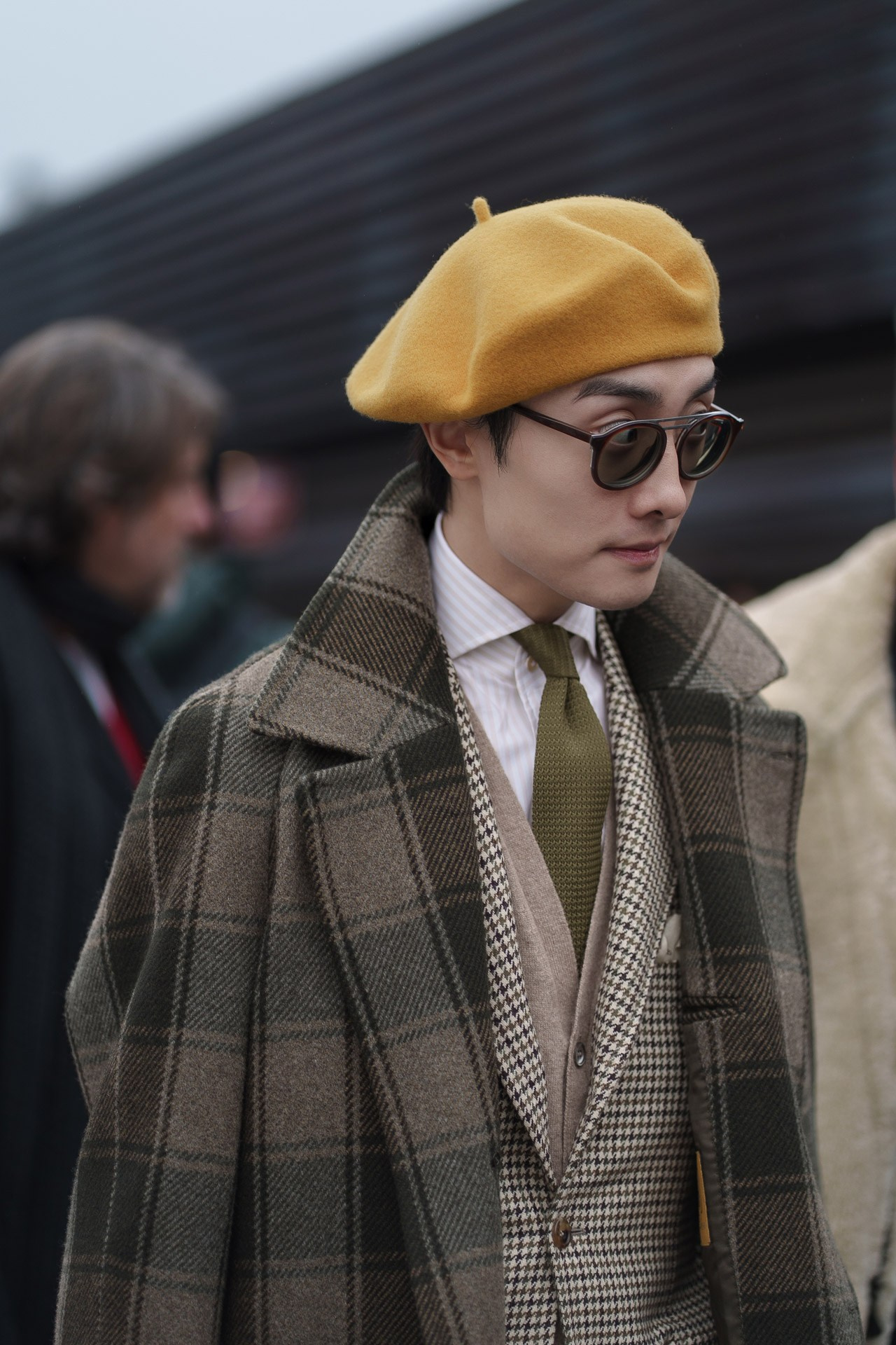 Man in yellow beret and checked coat at Pitti Uomo Florence street style