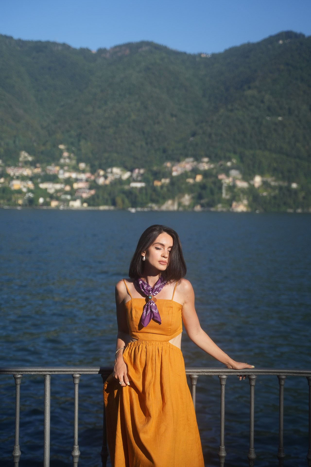 Portrait of a woman in an orange dress by Lake Como