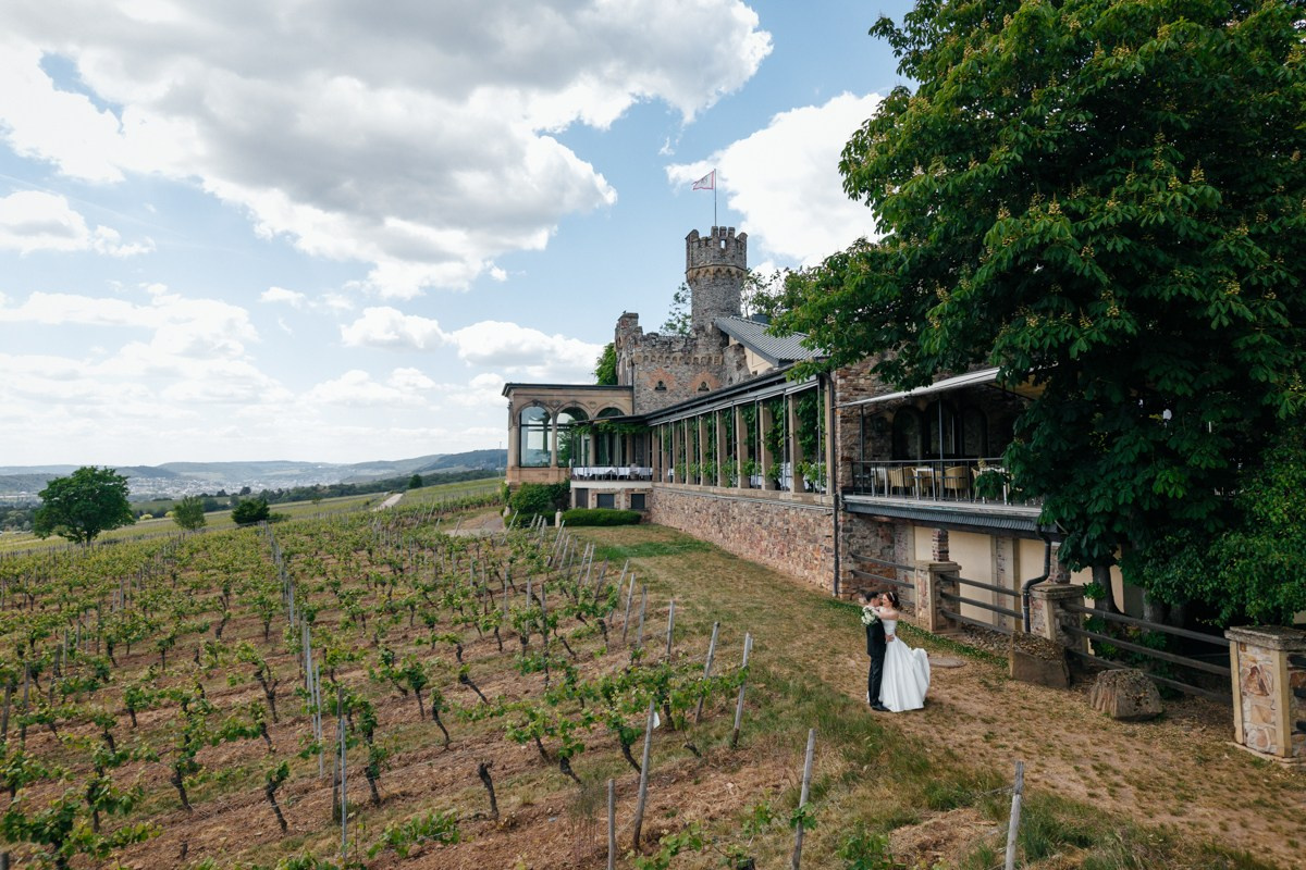 drone footage of bride and groom in front of burg schwarzenstein