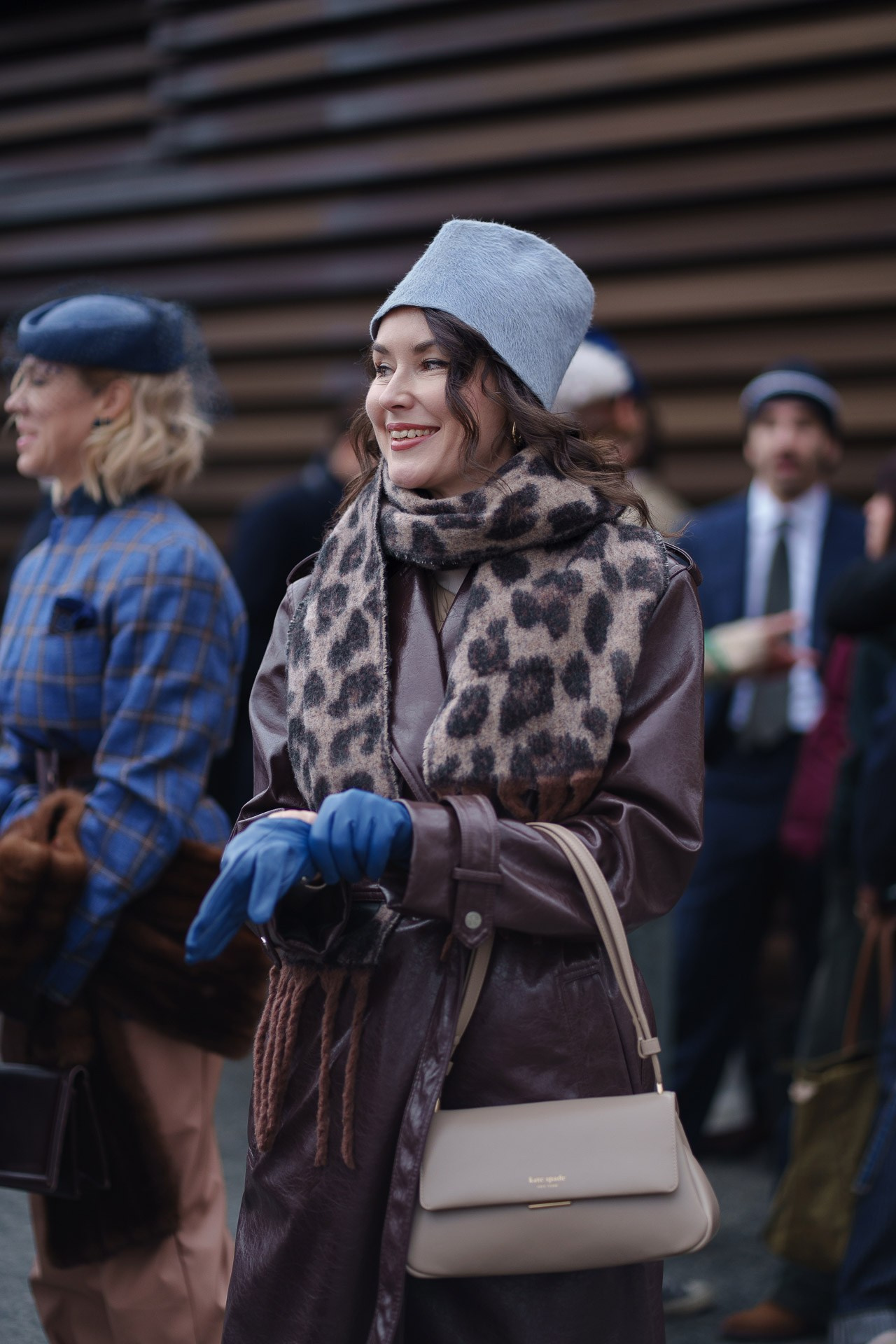 Stylish woman in brown leather coat and leopard scarf at Pitti Uomo 109