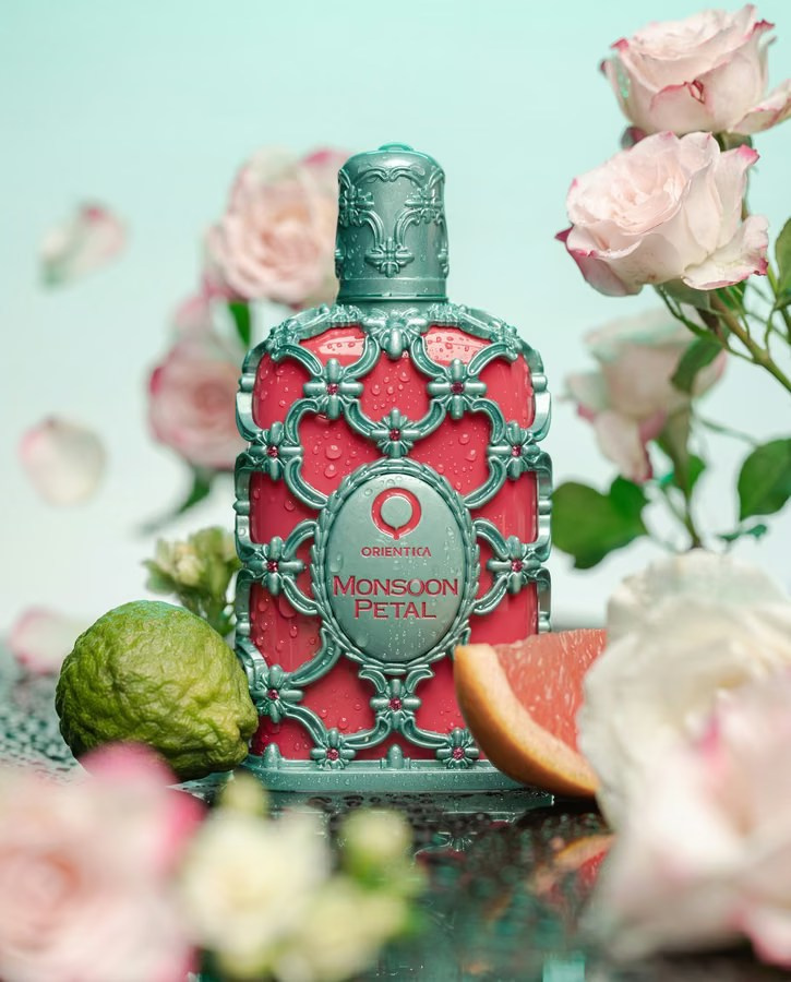 Ornate turquoise perfume bottle framed by soft pink flowers