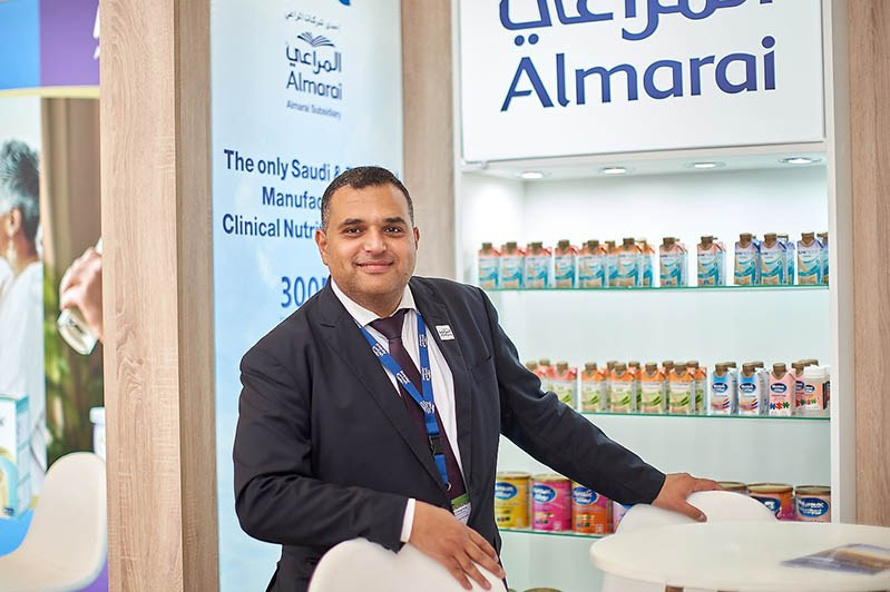 A company spokesman in front of a branding wall at the Prague Congress Centrum.