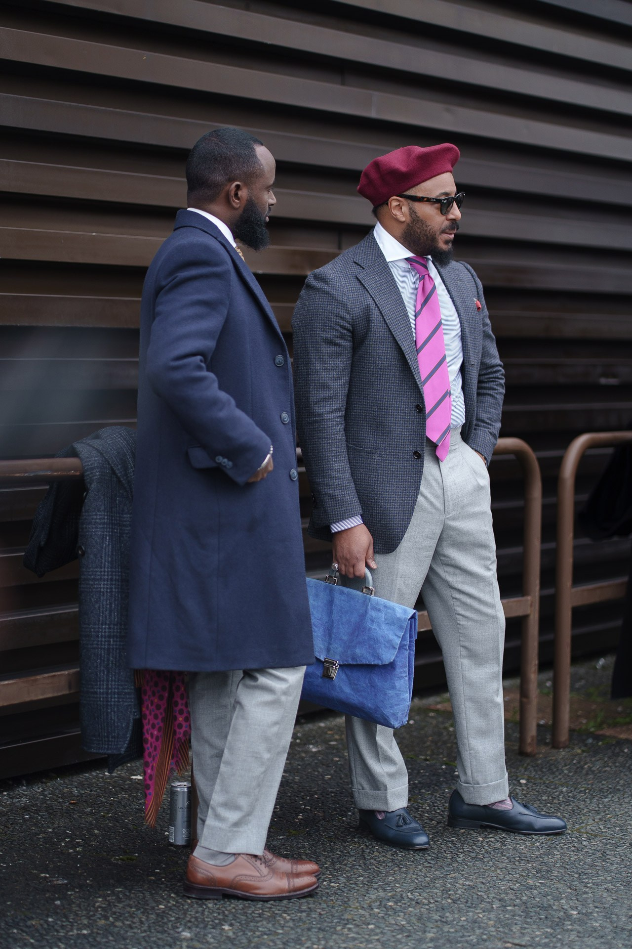 Two elegant men in tailored suits talking at Pitti Uomo Florence