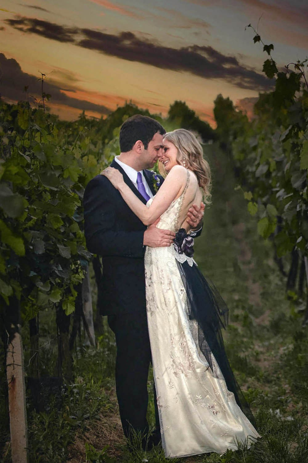 Stylish bride and groom embracing in vineyards at sunset in Moravia