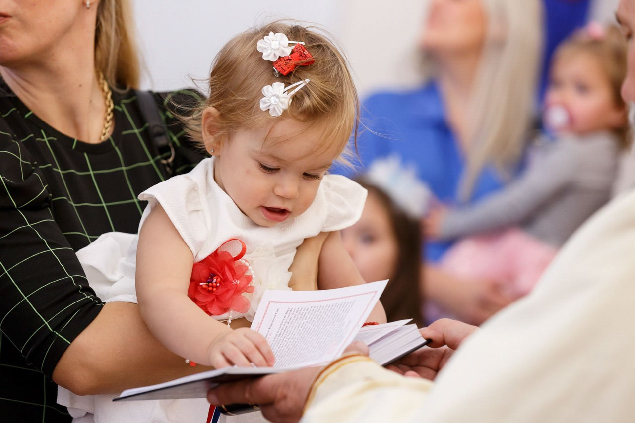 Beba i sveštenik tokom obreda krštenja – emotivna uspomena.