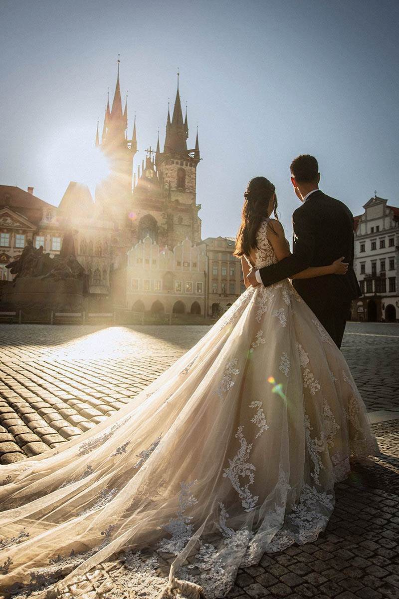 Couple silhouetted against Týn Church spires at dawn, Old Town Square, Prague