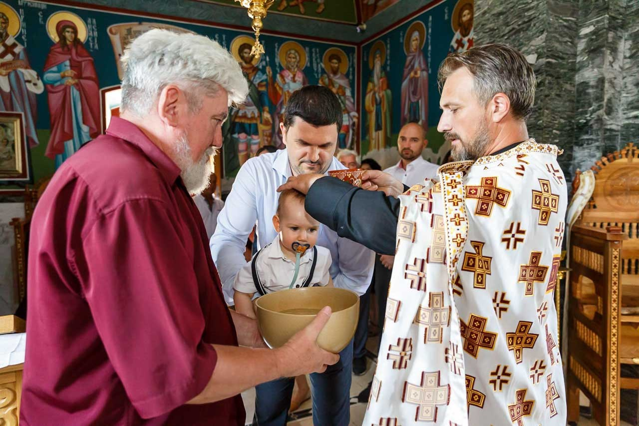 Pravoslavni sveštenici tokom ceremonije krštenja deteta.