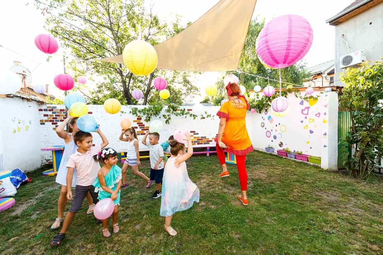 Proslava dečjeg rođendana u prirodi sa balonima i lampionima.