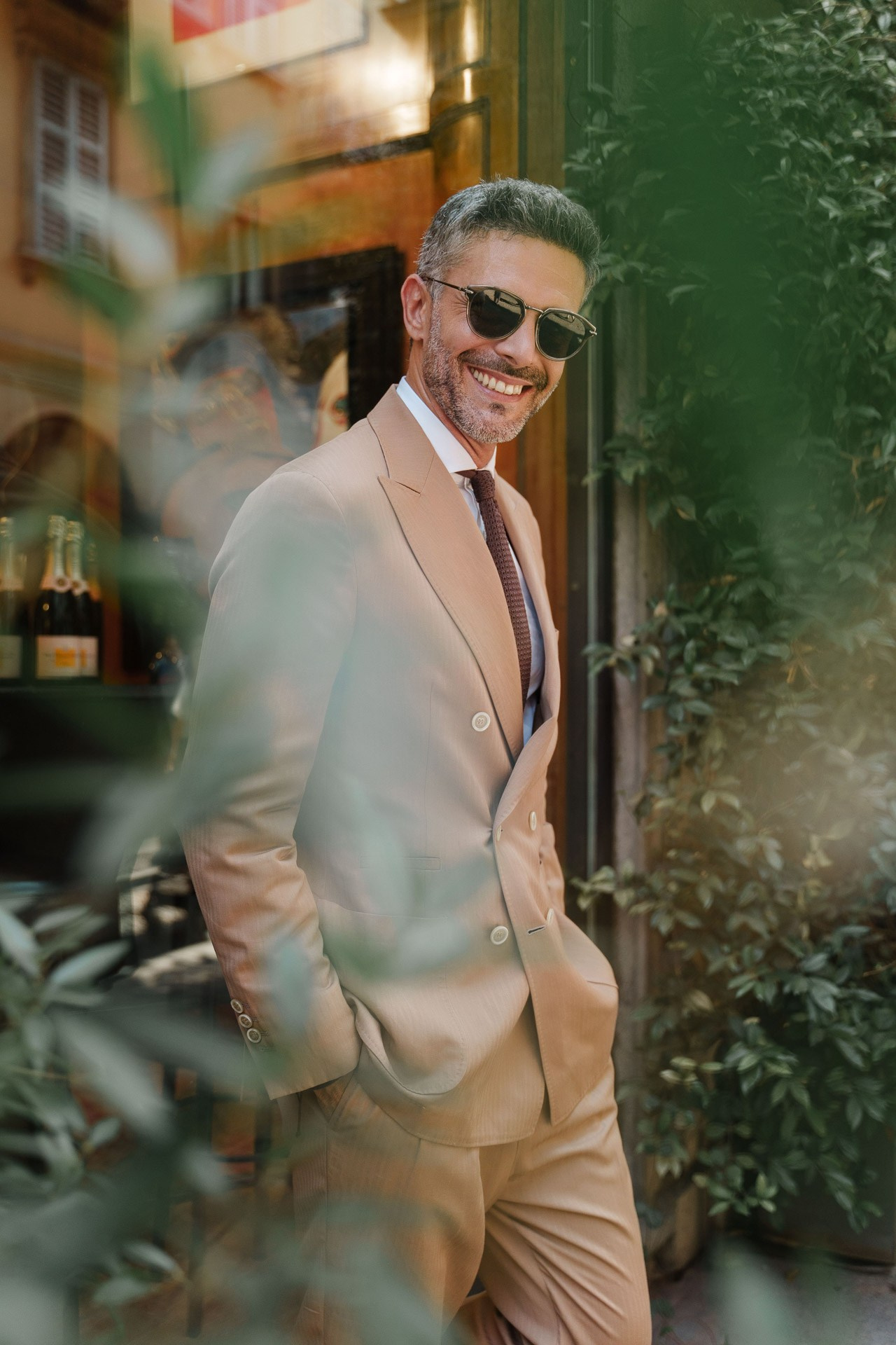 Male fashion model smiling in a beige suit during a lifestyle portfolio shoot in Milan