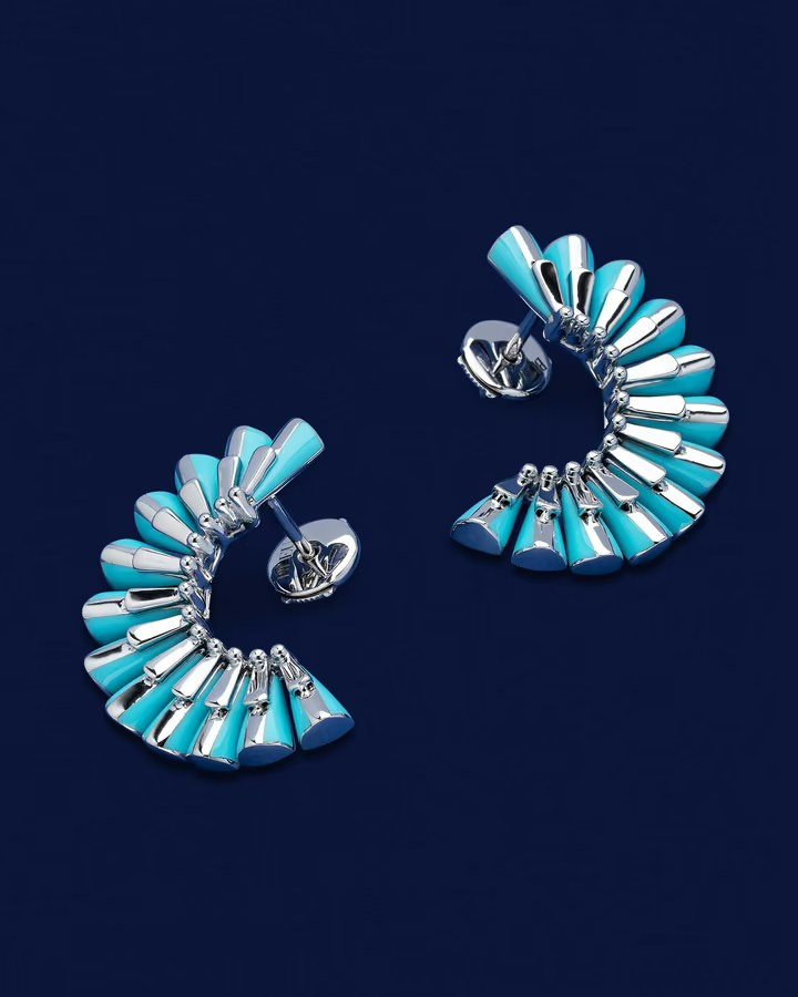 Stylish earrings featuring blue enamel and silver accents displayed on a deep blue background
