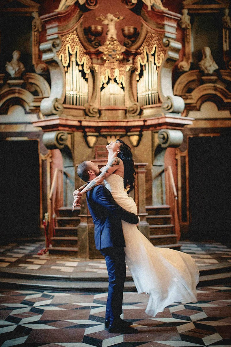 Groom spinning tattooed bride in the Mirror Chapel, Klementinum wedding