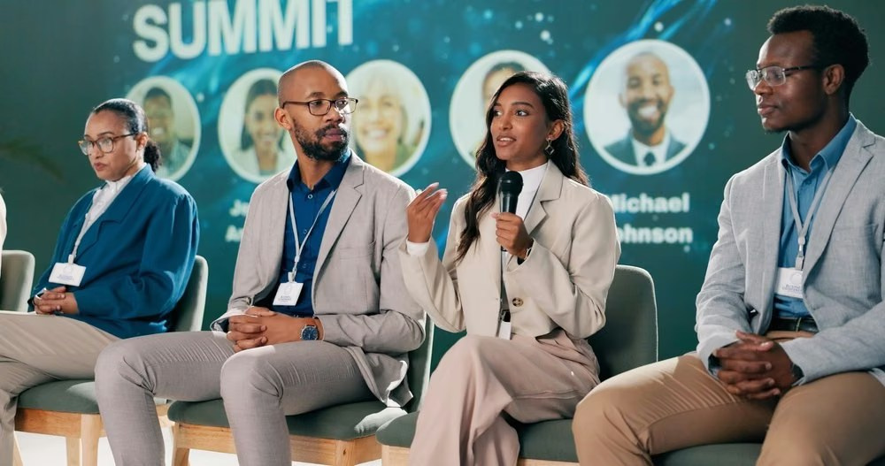 Diverse business leaders speaking during a summit panel discussion