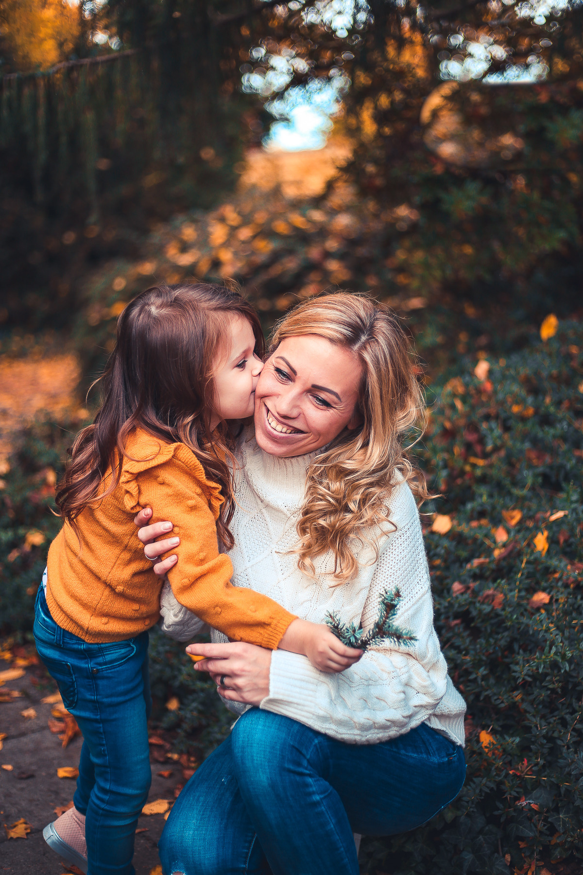Tochter küßt Mama, Mama lacht, Mama und Tochter spazieren im Park, Herbst