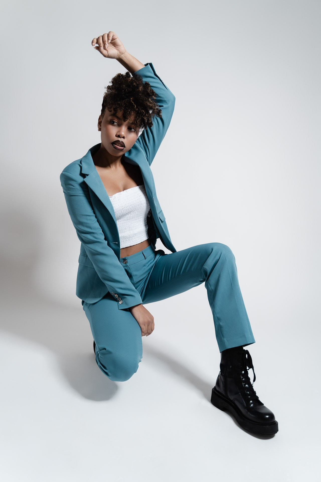 Studio portrait of woman adjusting her shirt in soft light