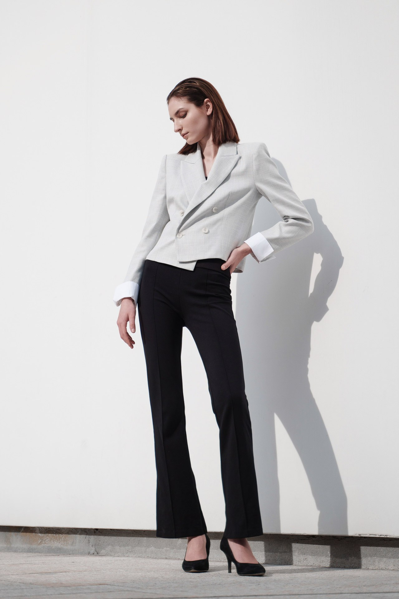 Female model posing in a white wall location for clean agency-ready digitals