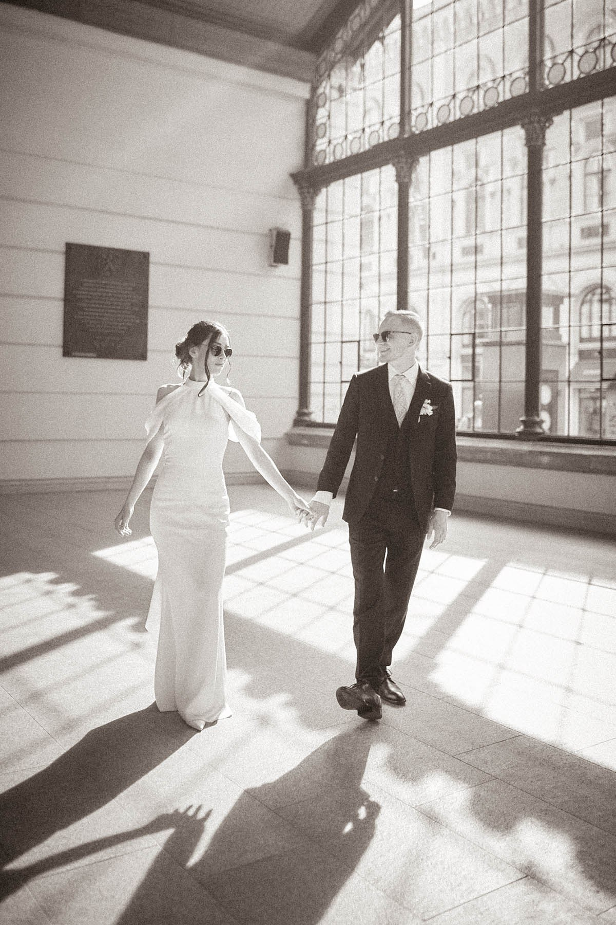 Bride and groom silhouetted in strong natural backlight at Prague's Masarykovo Train Station 