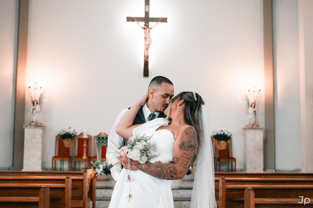 Noivos se abraçam no altar sob a cruz em Bariri.