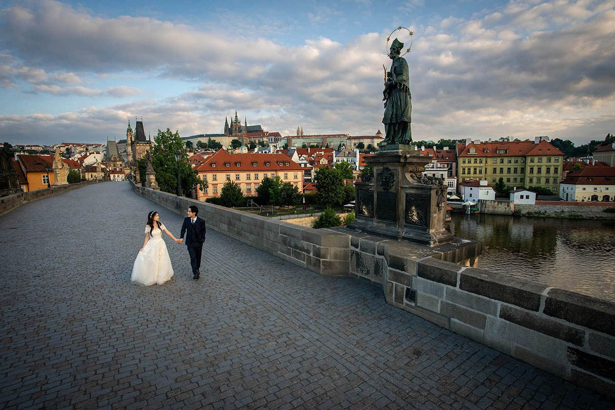 A Korean couple during their intimate morning walk on Charles Bridge