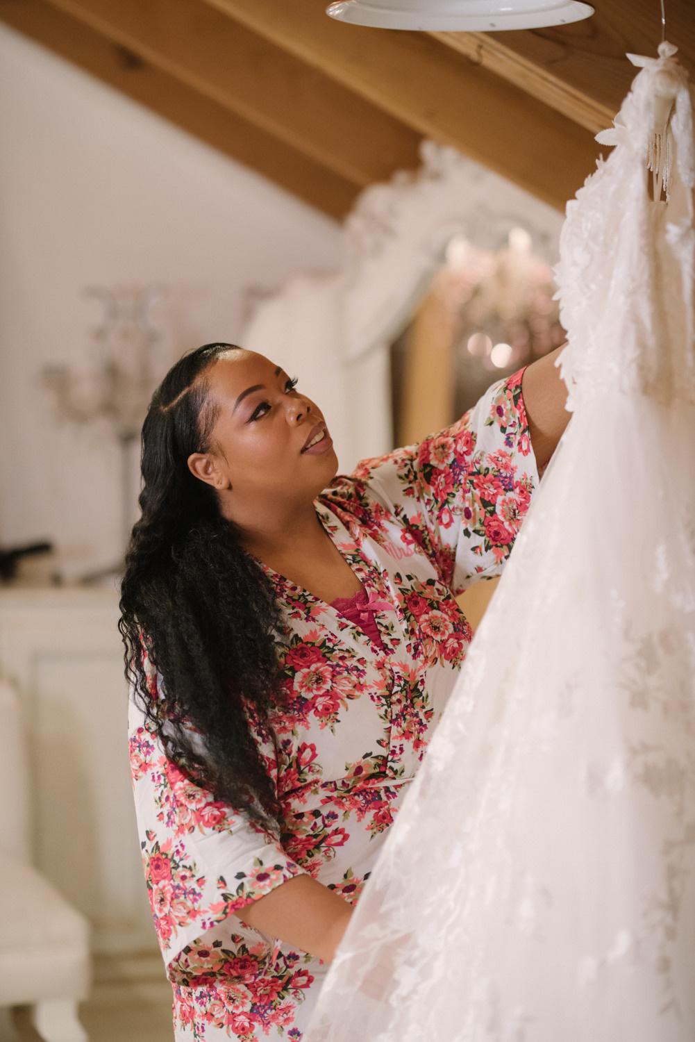 Невеста рассматривает свое свадебное платье. 