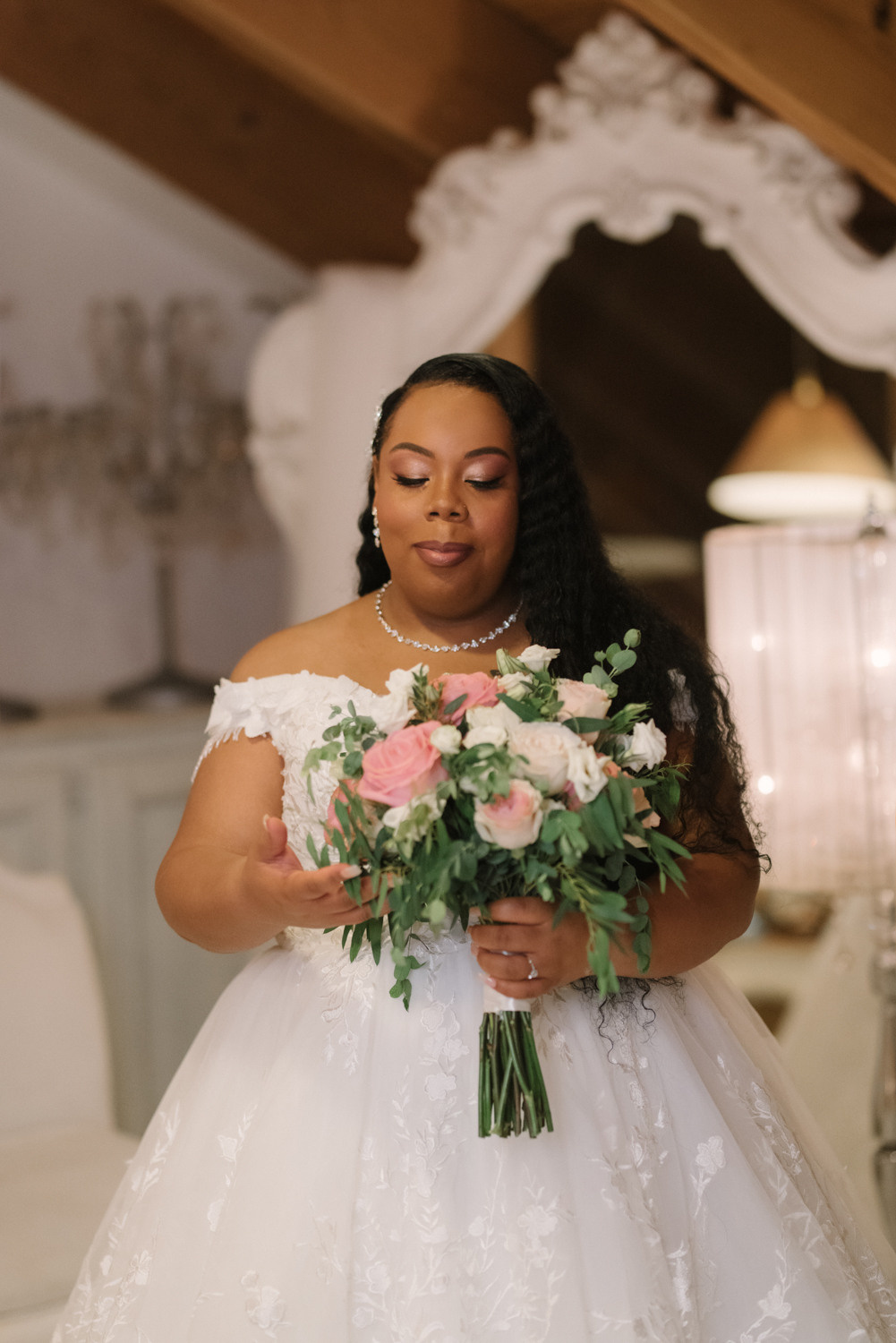 Невеста одета в белое свадебное платье. В руках у нее свадебный букет. 