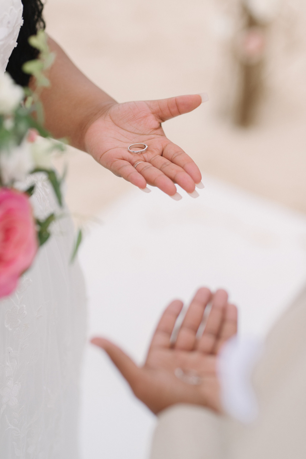 Невеста держит в руке обручальное кольцо.