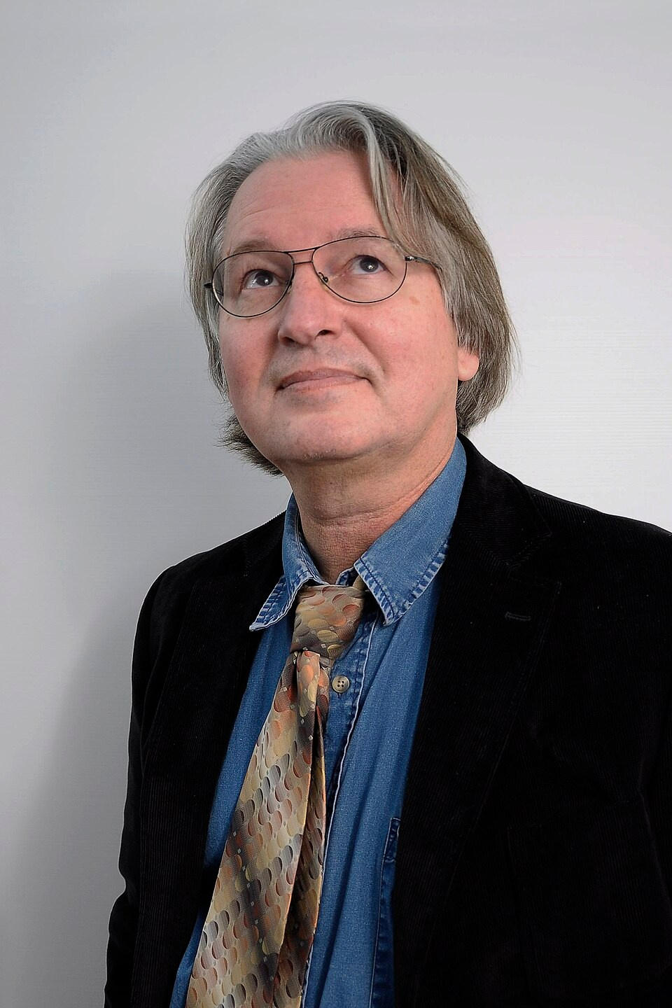 Портрет Брюса Стерлинга, американского писателя-фантаста и футуролога, сооснователя жанра киберпанк и раннего теоретика «Новой эстетики», известного исследованиями пересечения цифровых технологий, физической среды и культурных систем, выполнен в минималистичном стиле, вдохновлённом анти-дизайном и цифровым брутализмом. 