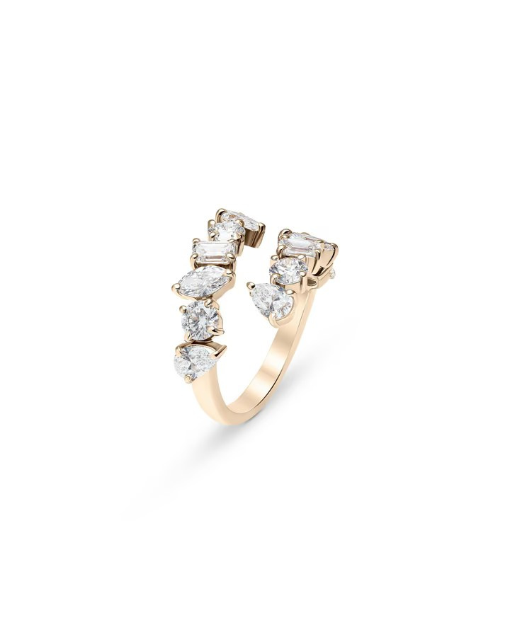 Open gold ring with pear-shaped and round-cut diamonds on a white background