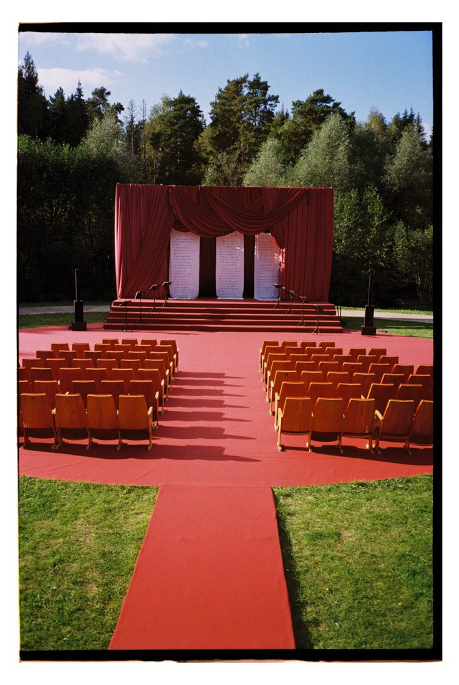 Outdoor ceremony aisle with red carpet during destination wedding setup