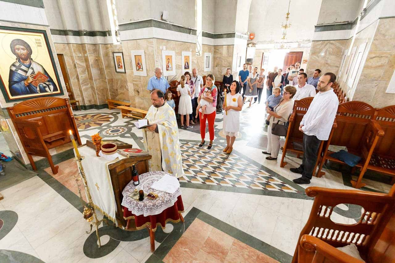 Svečan čin krštenja u tradicionalnom pravoslavnom ambijentu.
