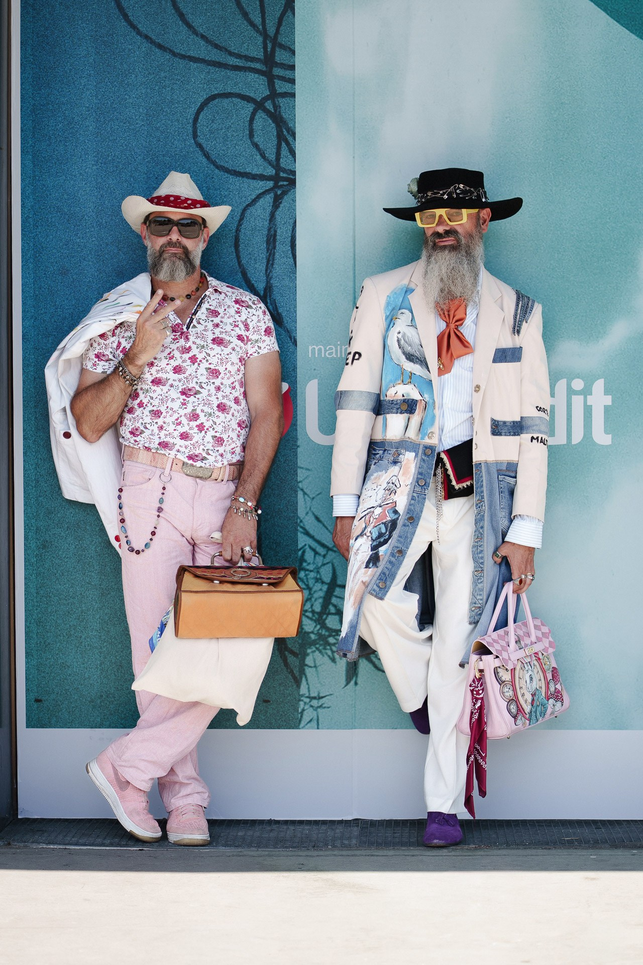 Two fashion guests in colorful summer looks at Pitti Uomo 110 in Florence