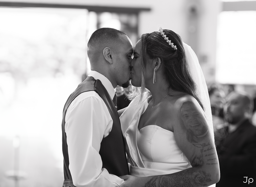 Casal de noivos se beijam durante a cerimônia em Bariri