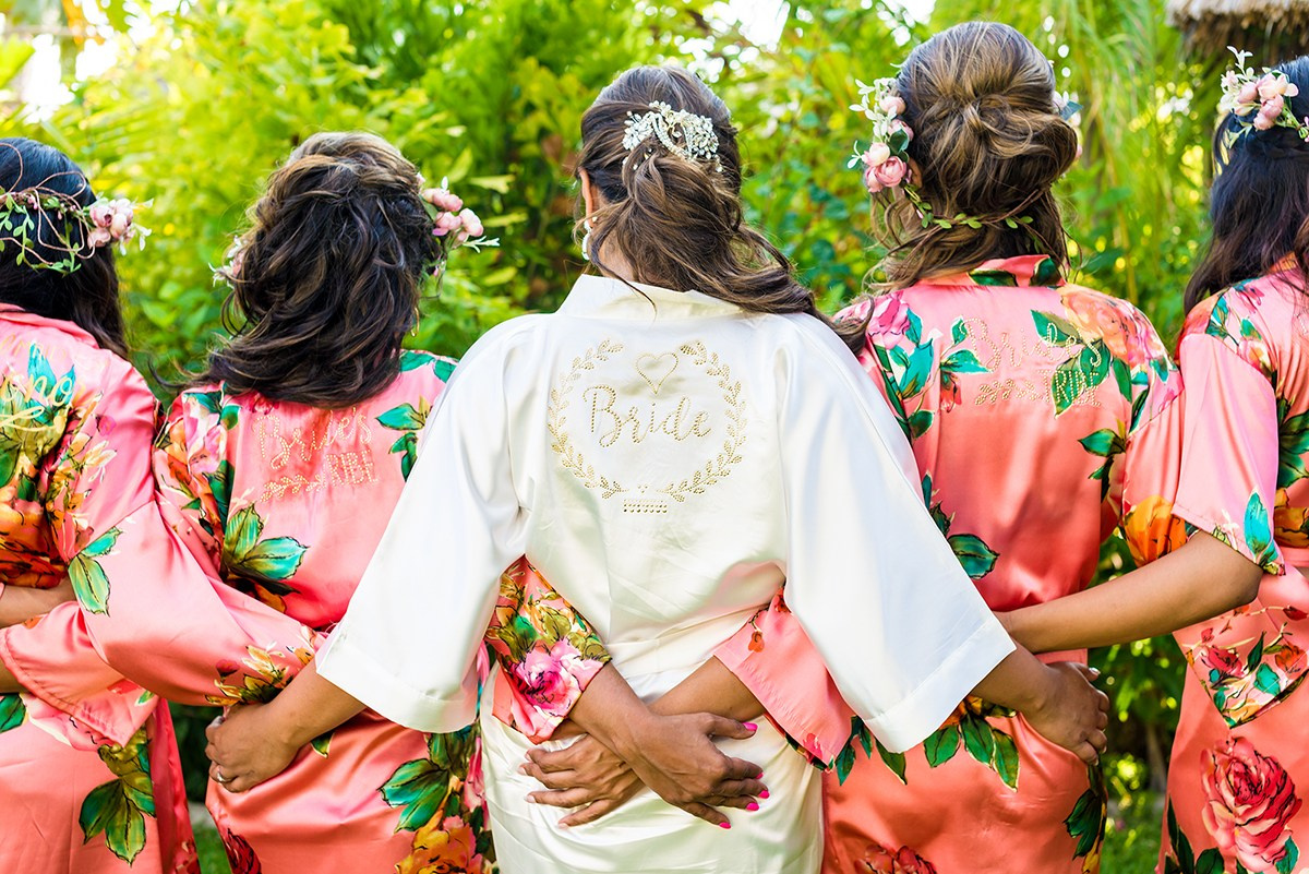 Bridal preparation in Los Cabos – bride hugging bridesmaids wearing robes before destination wedding