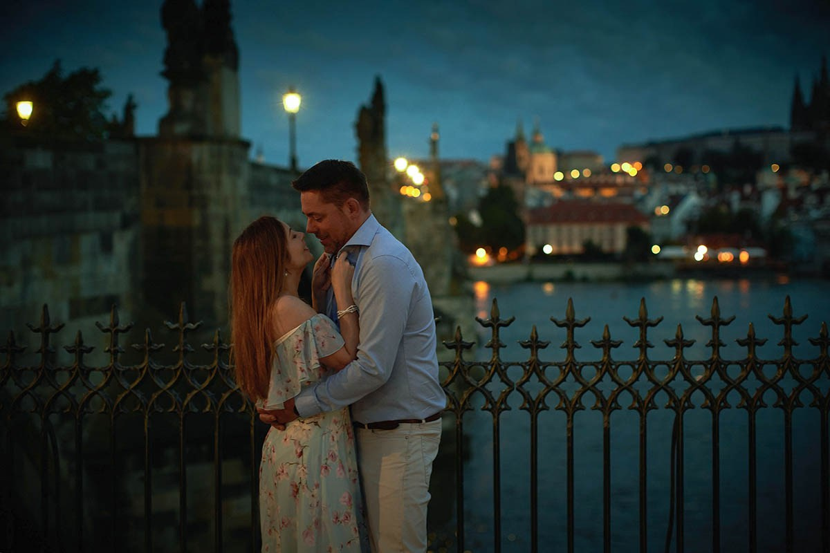 Stylish Czech couple in a sexy embrace overlooking the Charles Bridge in Prague.