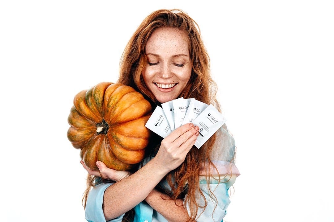 Model with wavy hair, exuding a sense of effortless beauty and natural charm. Her makeup is light, complementing her radiant skin. The background is neutral, allowing her expressive eyes and soft smile to be the focal points. This image celebrates the beauty of natural hair and minimalistic style.