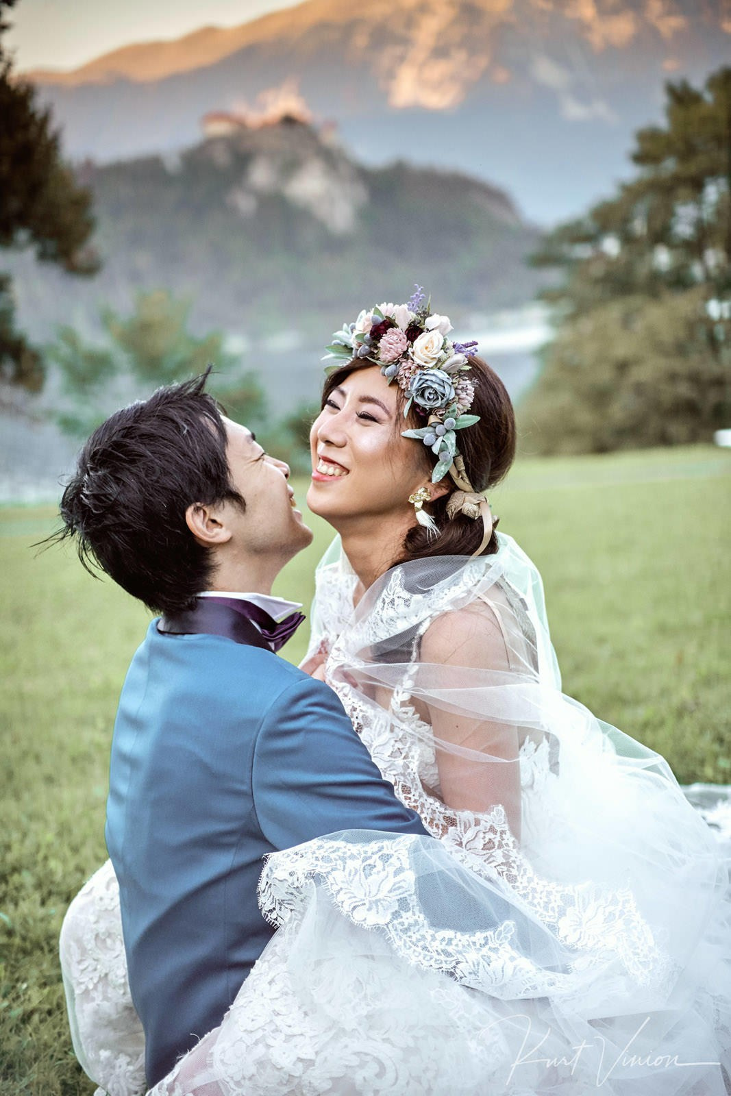 Bride uncovering groom's face both laughing twilight portrait.
