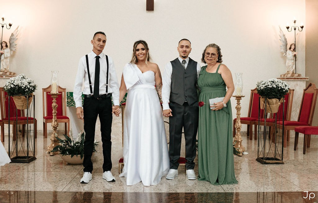 Noivos posam para Fotógrafo em Bariri com pais no altar da igreja.