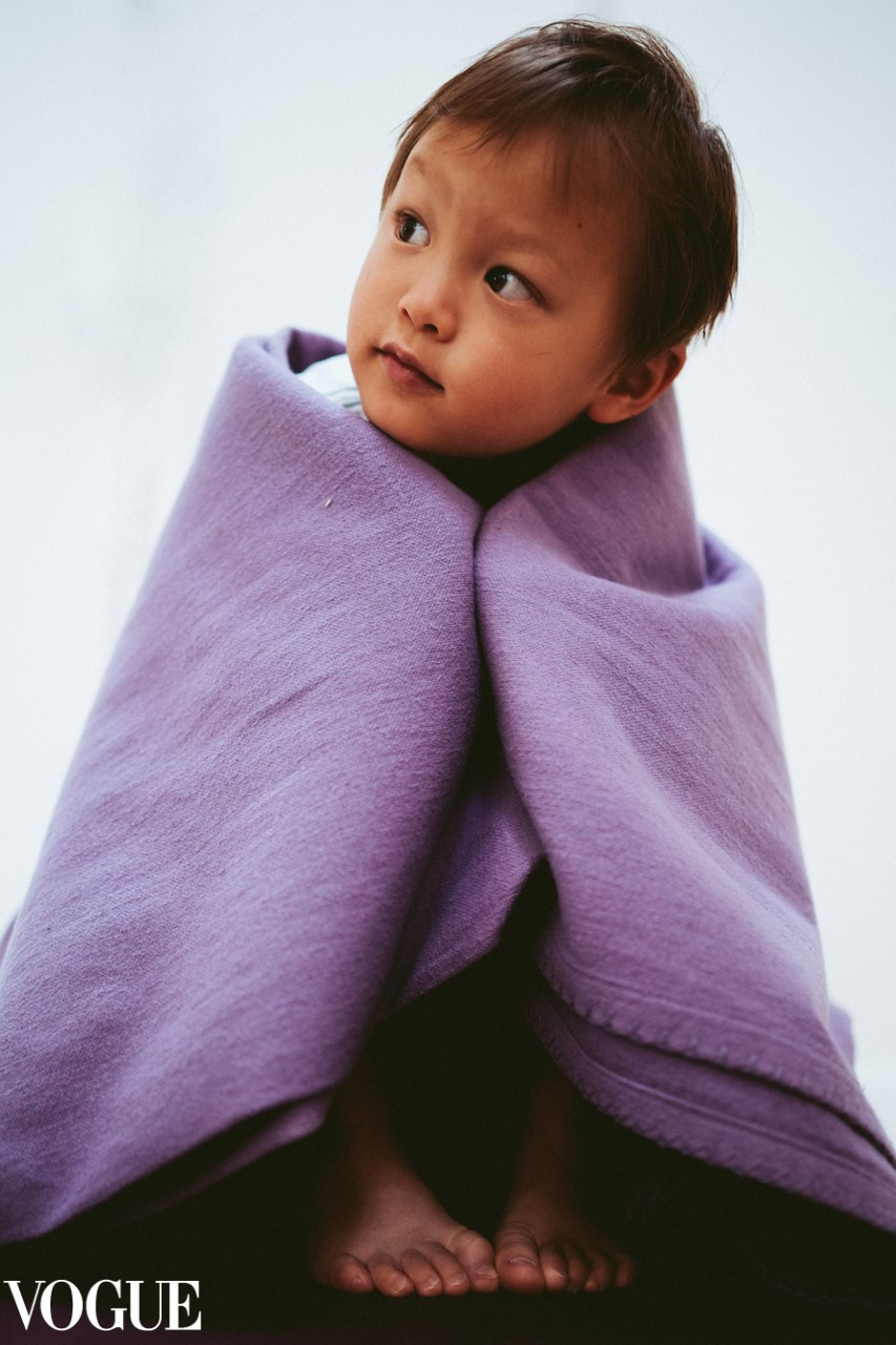 Child wrapped in soft purple fabric, tender baby portrait in Solihull.