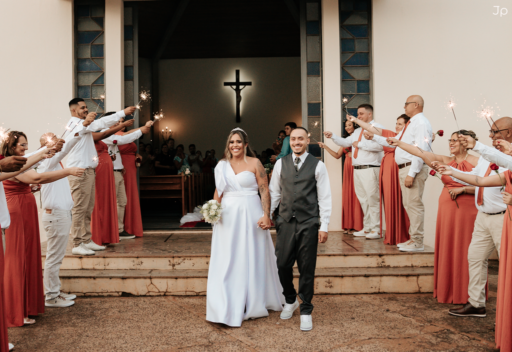 Casal no altar rodeado por padrinhos e madrinhas.