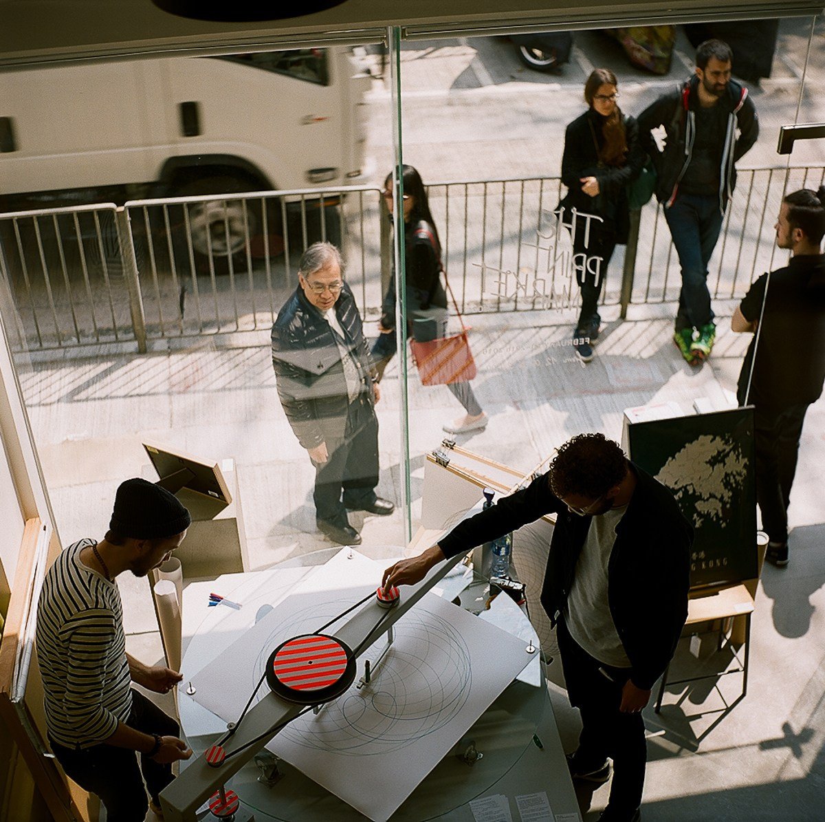 Menschen spielen Tischtennis während einer Veranstaltung in Hongkong und ein Mann schaut durch das Fenster auf sie
