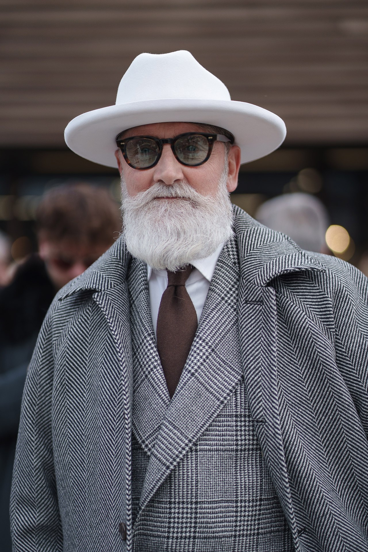 Bearded man in grey three piece suit and white hat at Pitti Uomo 109 Florence street style