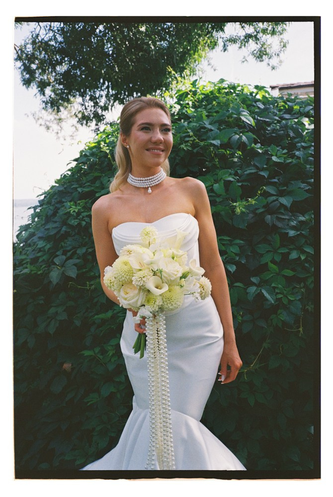 Bride smiling with bouquet during outdoor wedding portraits
