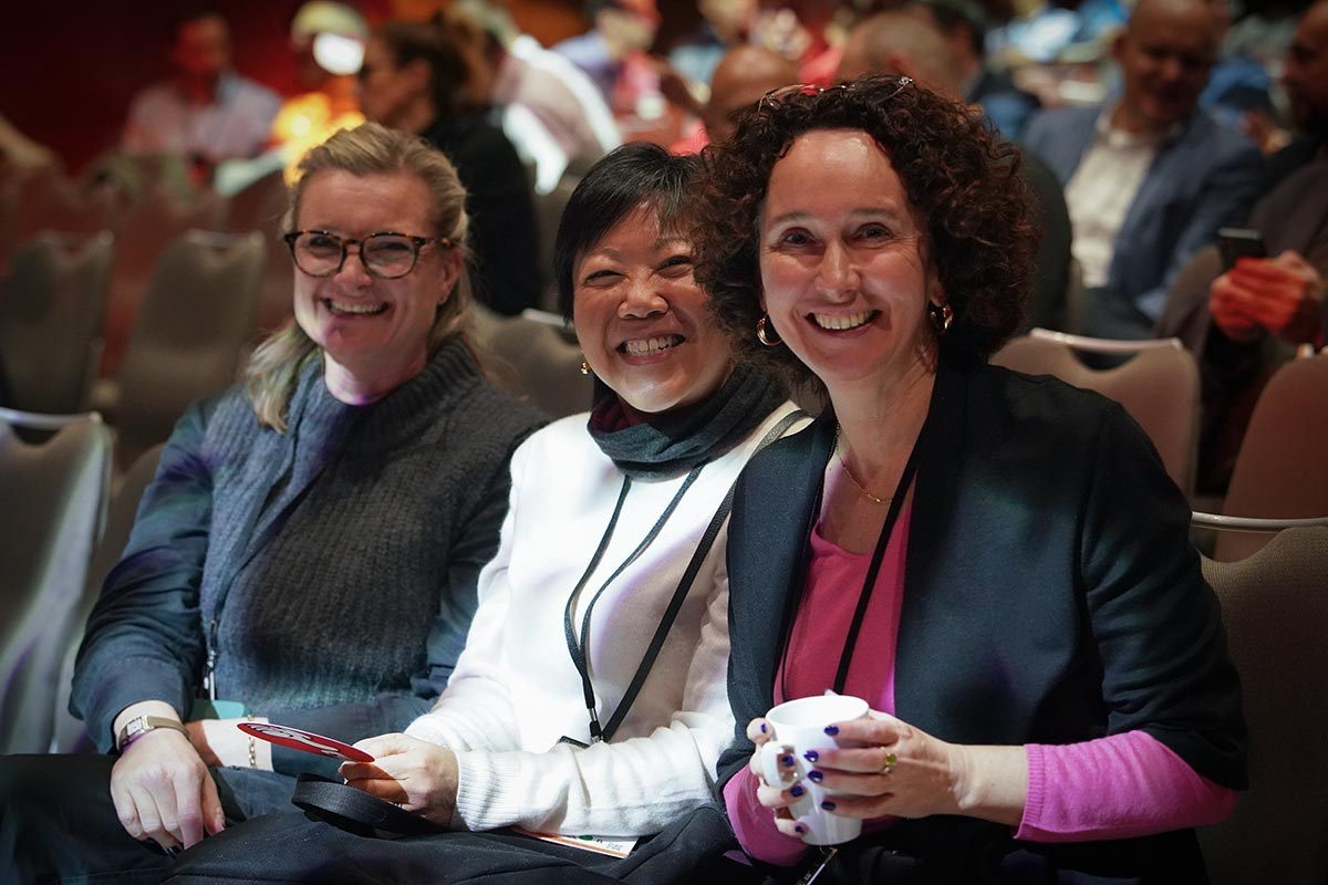 Members of the audience smile for the camera's gaze.