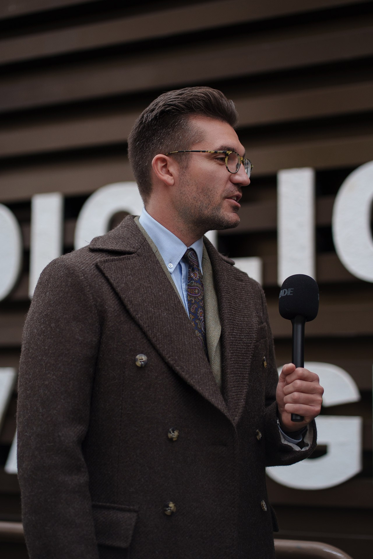 Man in brown double breasted coat being interviewed at Pitti Uomo Florence