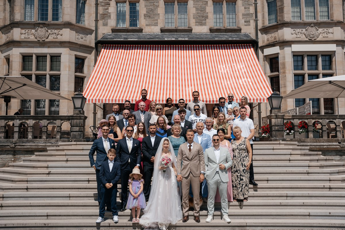 group photo of wedding party in front of kronberg castle
