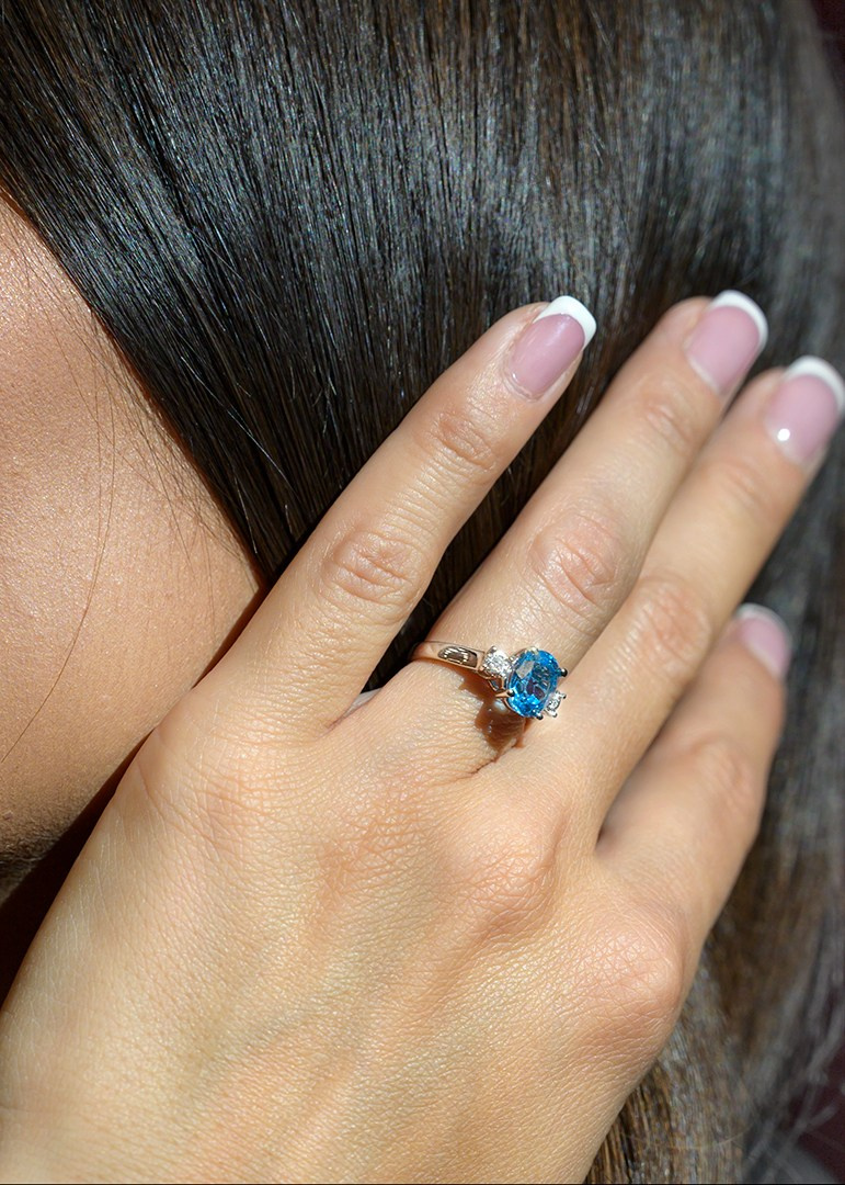 Prsten na ruci devojke plavi kamen.